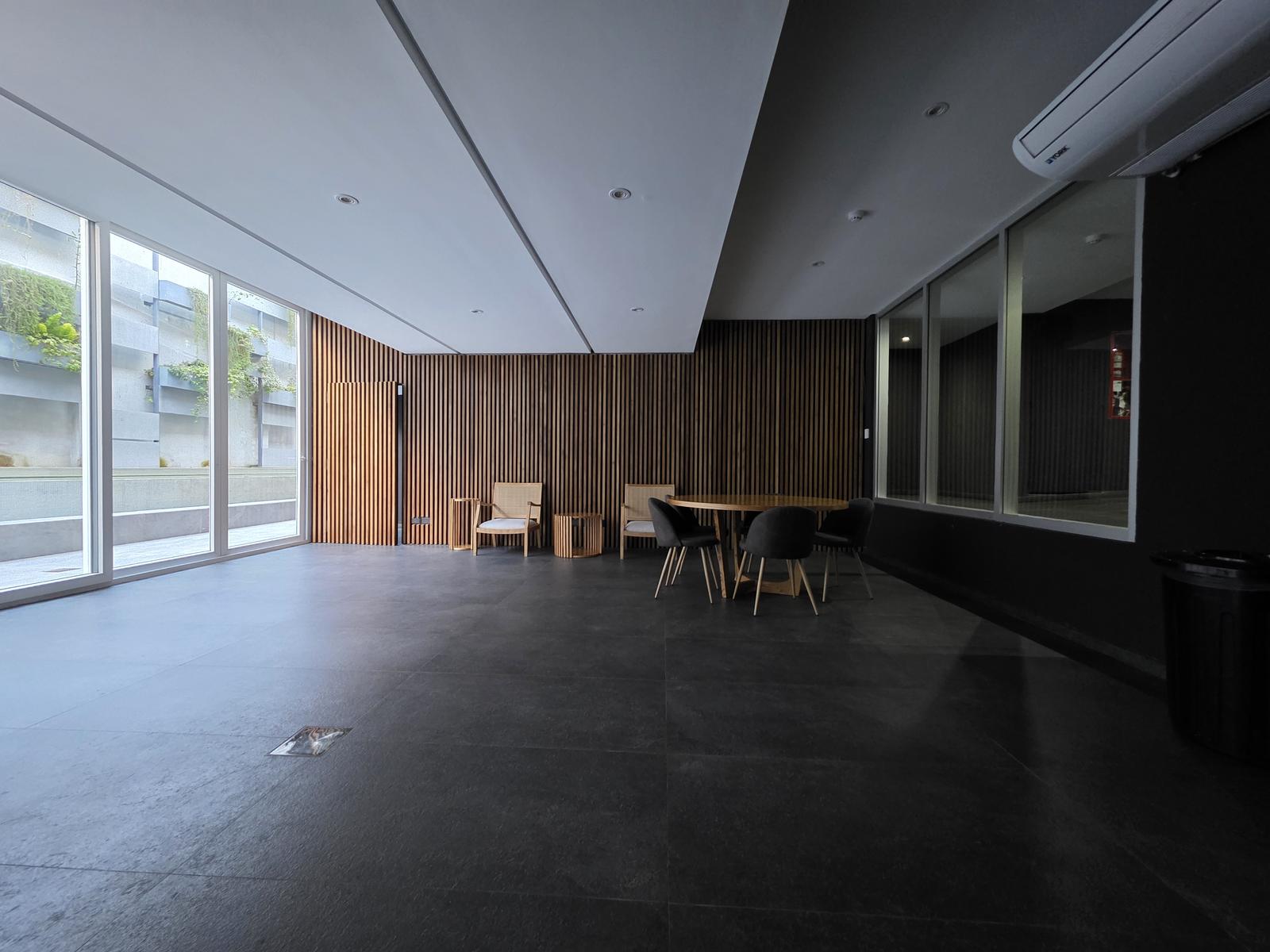 Salon de usos multiples de un edificio en Buenos Aires con revestimiento de madera
